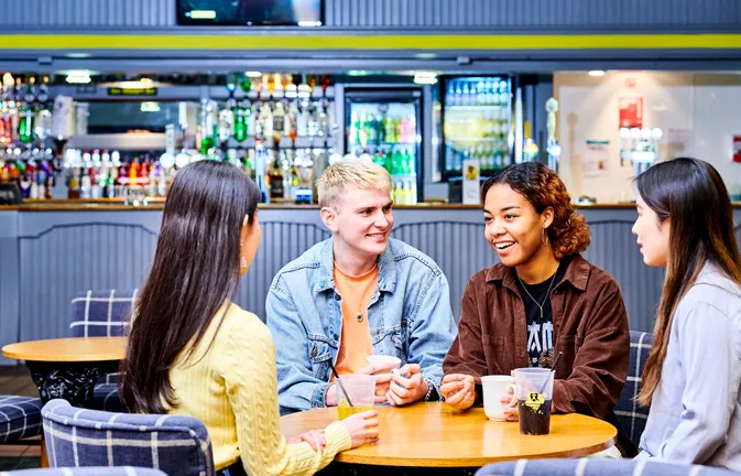A group of students sit in front of the bar at Van Mildert College