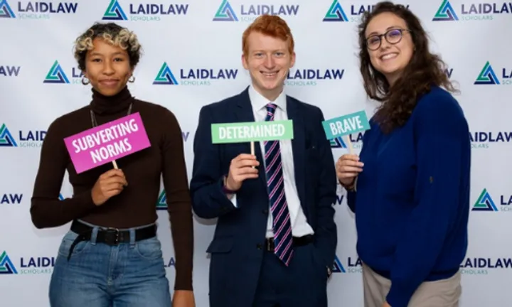 Three students holding Laidlaw messages