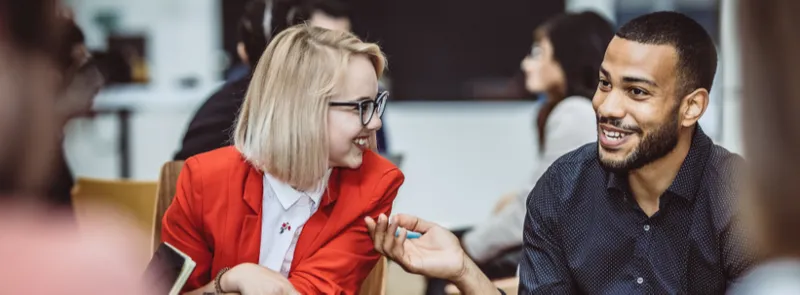 Diverse male and female colleagues smiling whilst talking