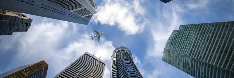 Plane in the sky surrounded by skyscrapers