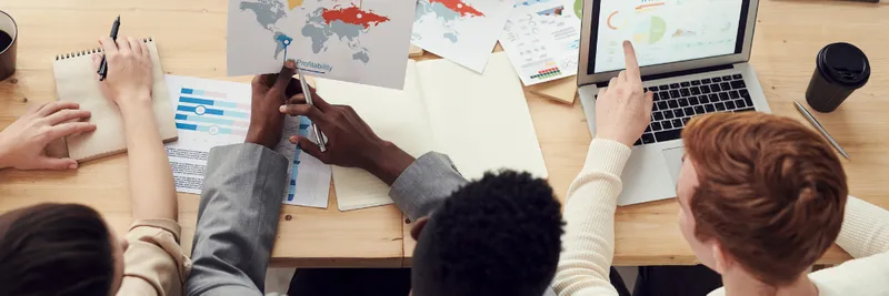 Group of diverse people seated around a table analysing data