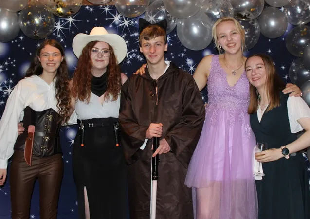 A group of friends smiling at camera at a society event