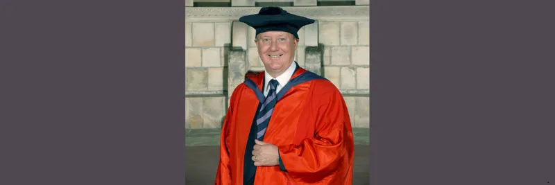 Kenneth Calman wearing a red graduation robe