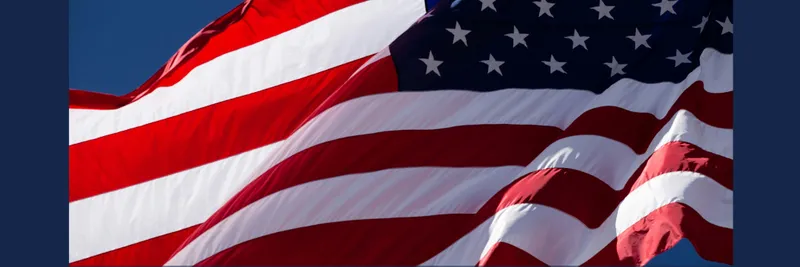 The USA flag fluttering in the wind with patches of blue sky