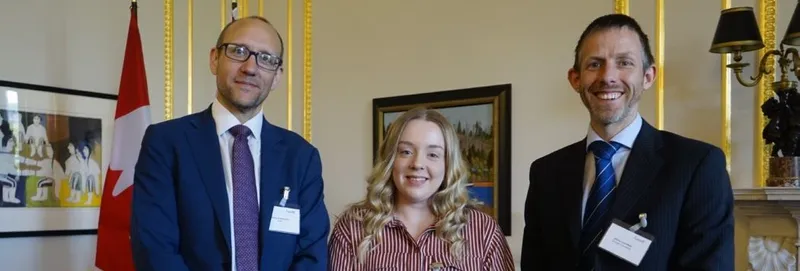 A student standing with two representatives