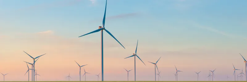 Group of windmills for electric power production in the green field of wheat