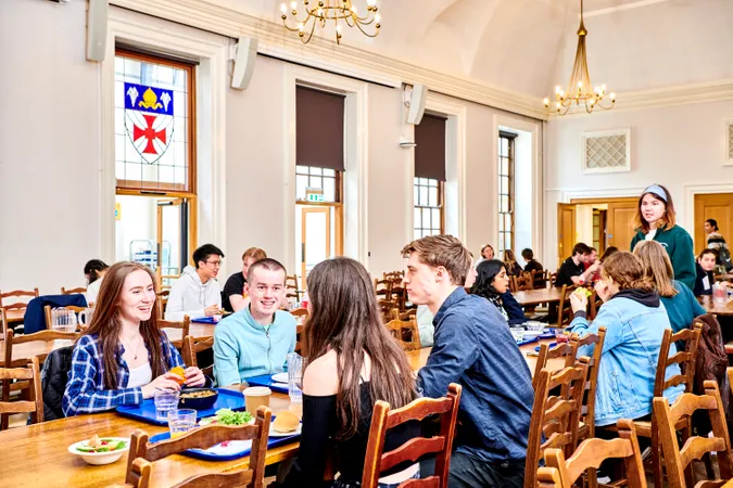 A wide shot of the dining hall with many students enjoying their meals and talking with one another