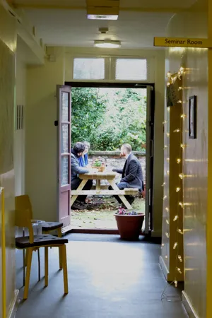 Group of people discussing philosophy books seen through a doorway
