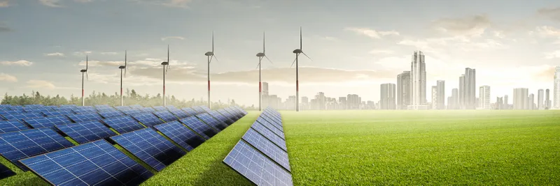 An image of solar panels and wind turbines with a distant industrial landscape