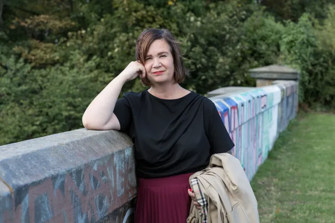 Paula mid shot leaning on stone bridge