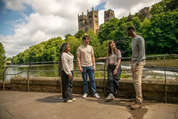 Four students talking with Durham Cathedral in the background