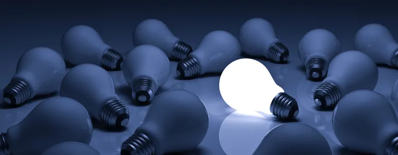 Lit bulb among dark bulbs illustrating leadership