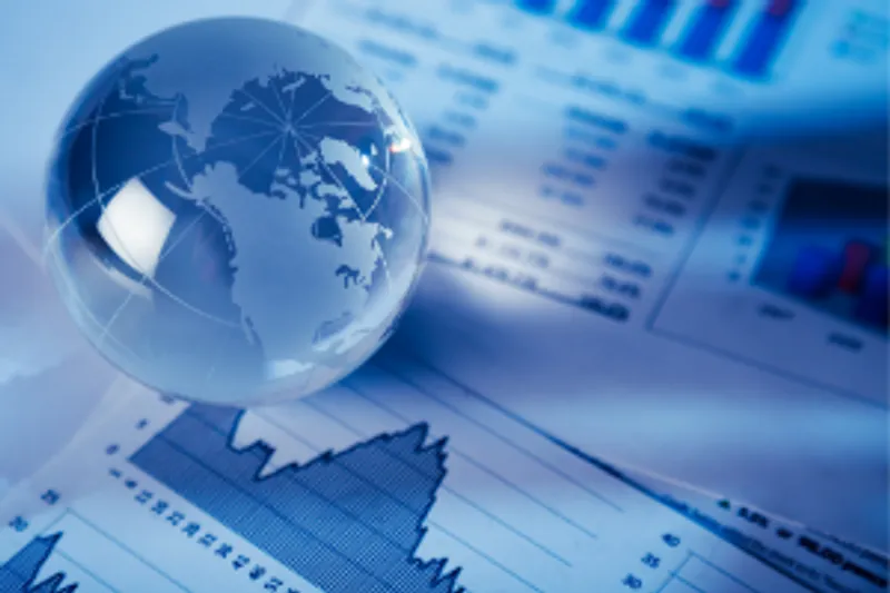 A glass globe sitting on top of financial graphs