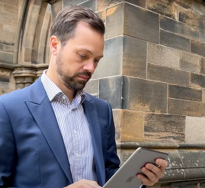 Image of man in suit looking at ipad