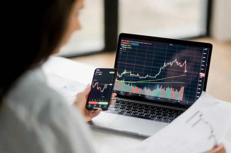computer and women analysing graphs of stock mark - iStock