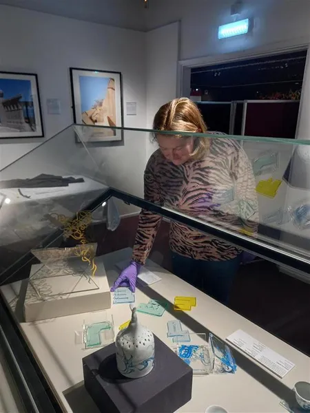 Carolyn Waterworth installing objects in a museum display case