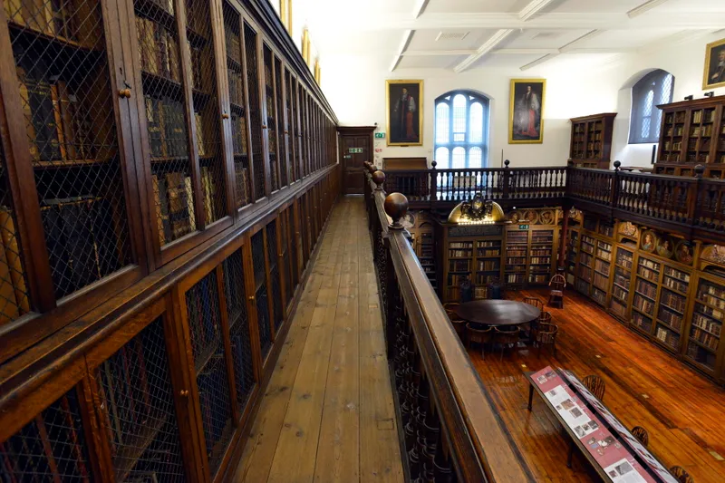 Cosin's Library balcony with bookcases lined along it and a view of the lower level bookcases in the background