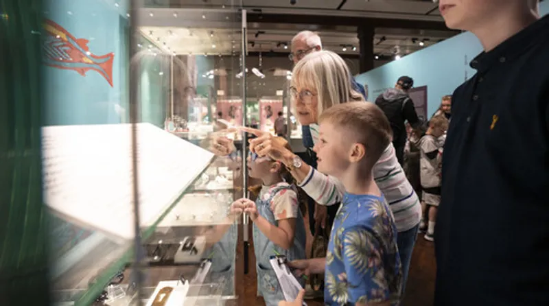 A grandparent and child looking at a museum case