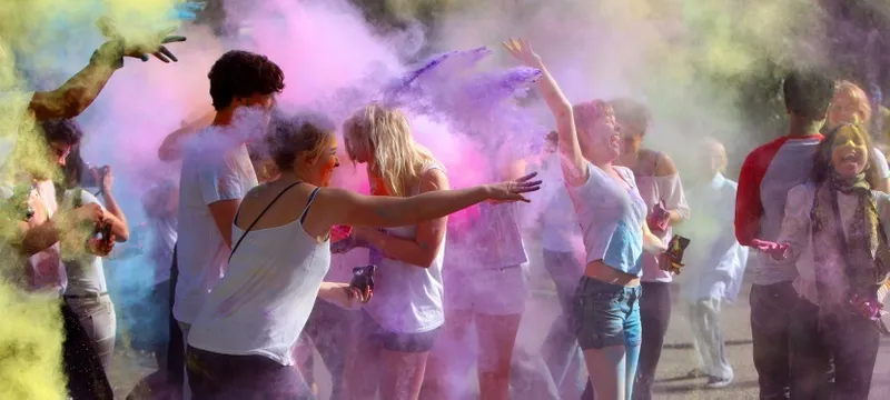 People throwing coloured powder at a Holi Festival