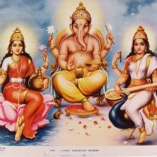 Colour print of three Hindu gods named Lakshmi, Ganesh and Saraswati. Lakshmi, shown as a woman with four arms and wearing a red sari with a gold crown, is sat on a lotus flower and is holding two lotus flowers and a golden pot, while coins flow from her remaining hand.