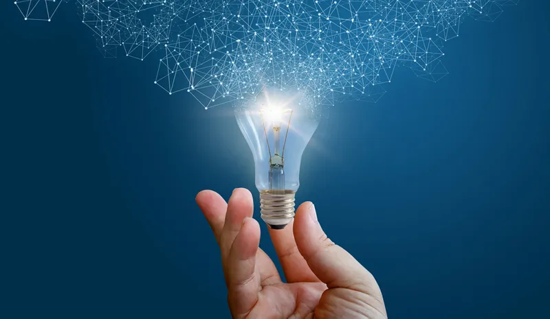A male hand holding a lightbulb exploding with ideas and opportunities