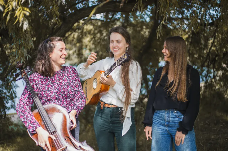 The all-female band The Portrait Players posing with their instruments in the woods