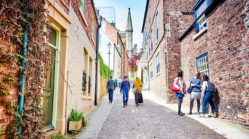 Two students walk down the cobbles of bow street