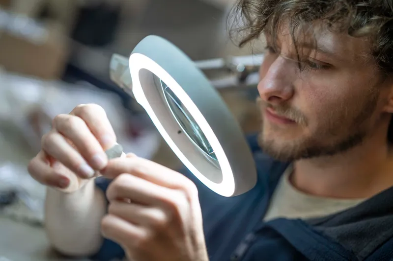 Person studying an artefact under a ring light