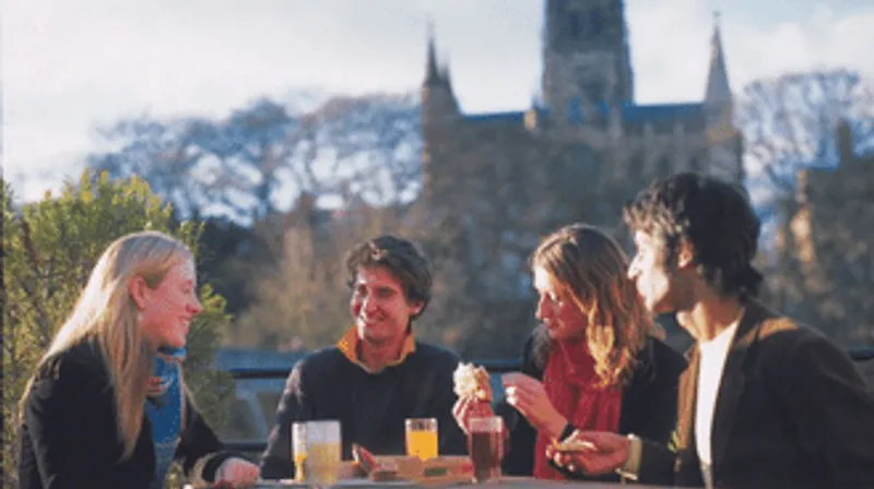 A group of students outside having lunch with cathedral in the background