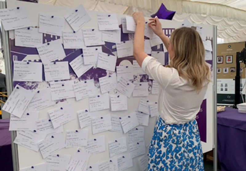 Student pinning a memory on the memory wall at congregation
