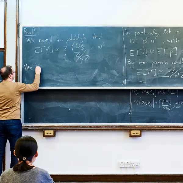 Lecturer writing on a blackboard
