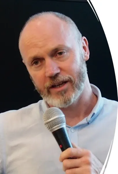 A man with a short beard talking into a microphone