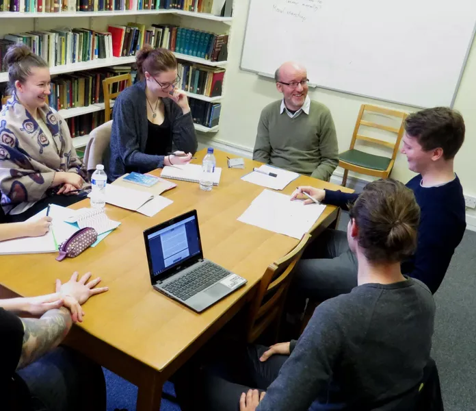 A group of Philosophy students and a lecturer sat around a table during a seminar