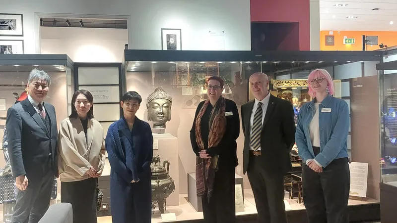 A mixed group standing in front of a museum display case