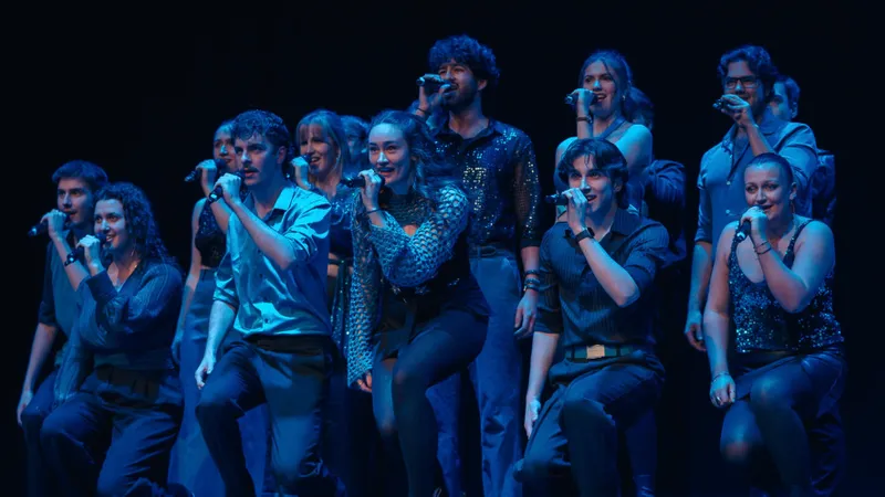 A group of dimly lit singers performing on stage