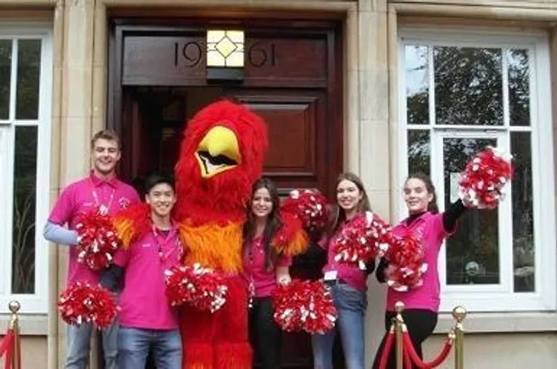 Event advert for a College Open Day featuring students dressed in pink tops standing with their phoenix mascot