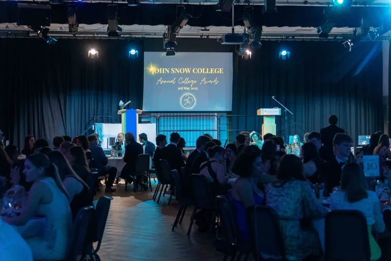 A photo taken of the audience and presentation at the 2025 Annual College Awards