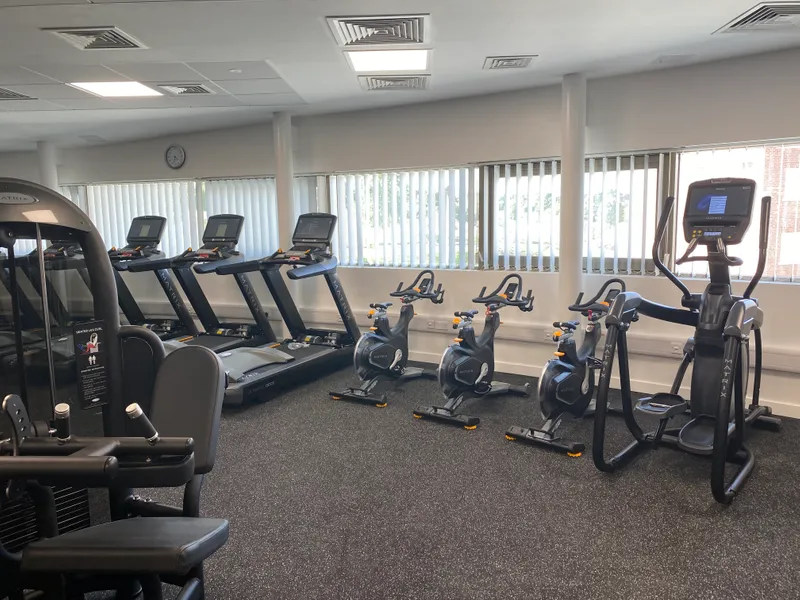 A picture inside the South College gym, showing various gym equipment, including stationary bikes, running machines, and a stair climber
