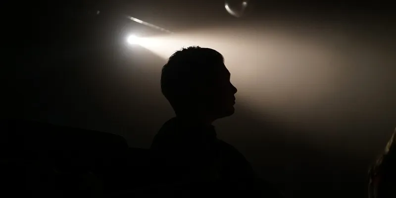 Silhouette of a student under a spotlight