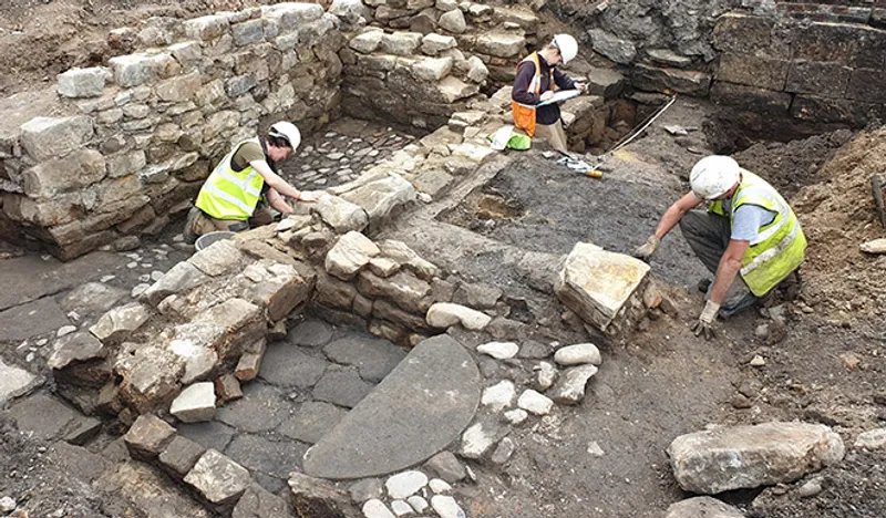 Three people excavating walls and foundations of a building