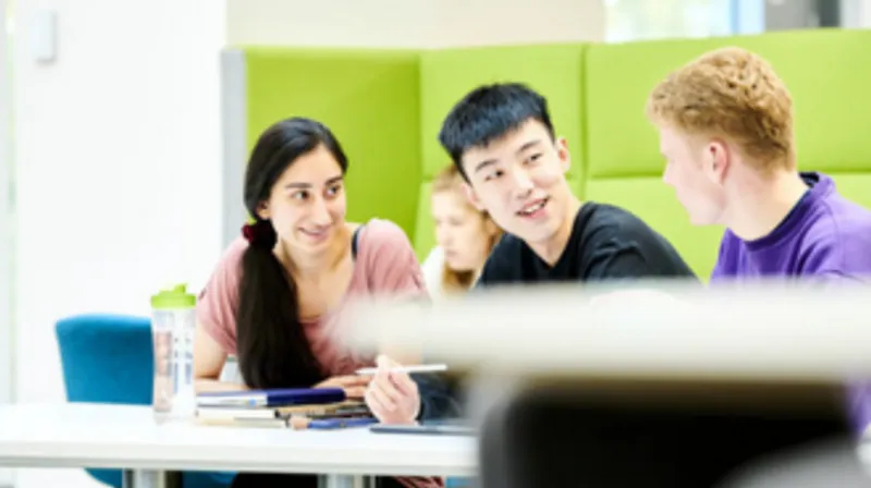 Two male and one female student sitting together in the Teaching and Learning Centre.
