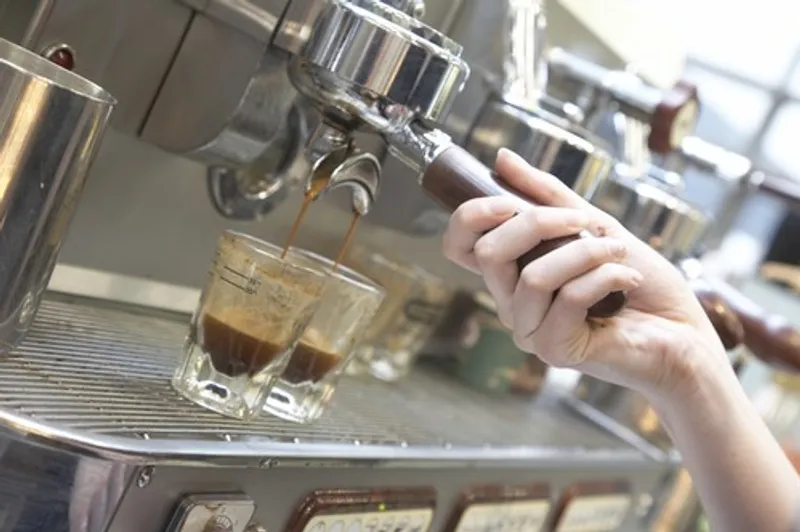 Someone making coffee at a coffee machine