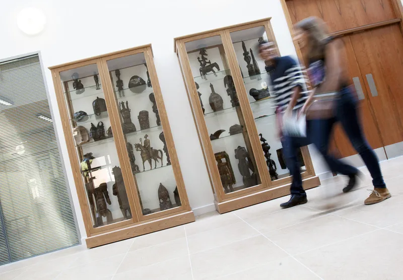 Students walk past African art exhibit