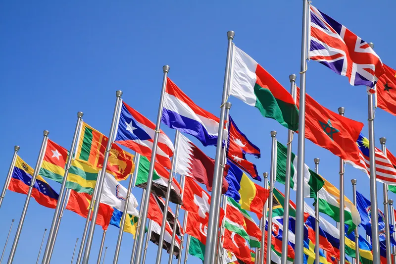 Lots of different flags against a blue sky