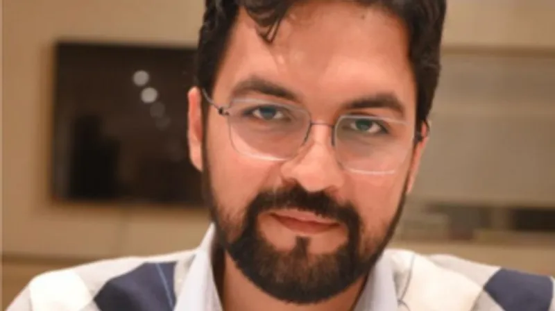 An image of a man with a beard wearing glasses.