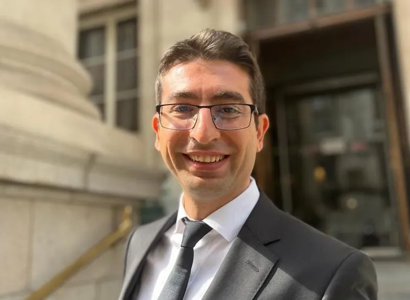 Dr Can Eken wearing a suit and tie