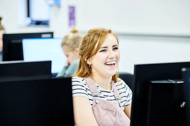 Maths students sitting in front of a screen in the computer room