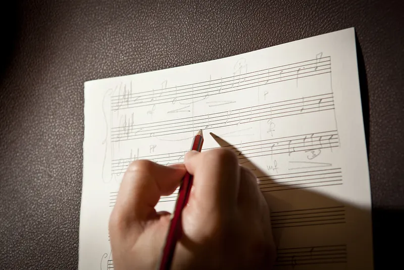 Someone writing sheet music