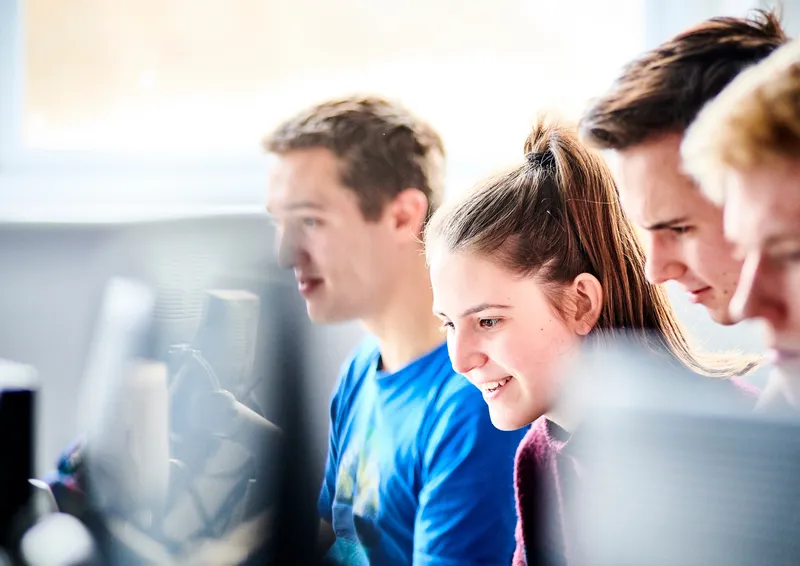 Male and female student looking at laptop