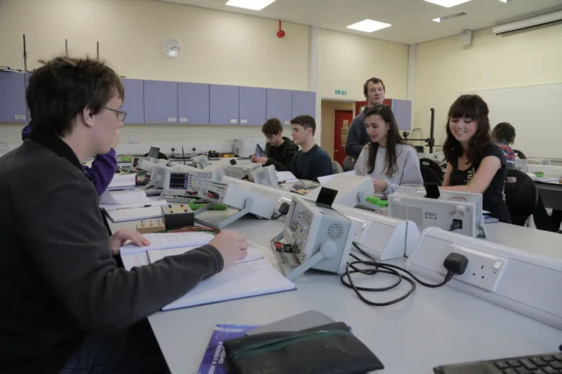 Students using oscilloscopes as Peter Swift looks on